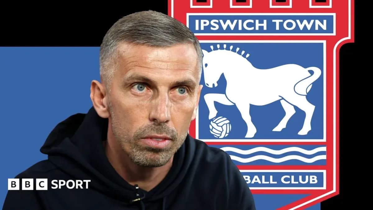 Manager speaking with Ipswich Town logo in background