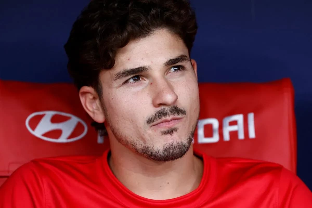 Player sitting on bench in red jersey