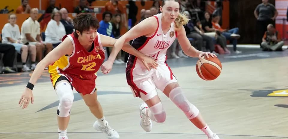 USA player dribbling past China defender during game