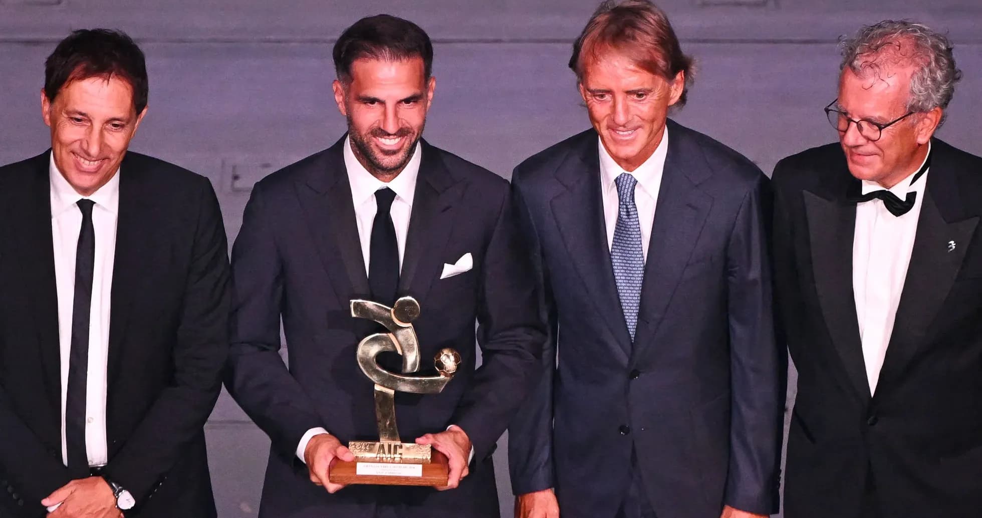 Four men holding an award at a ceremony