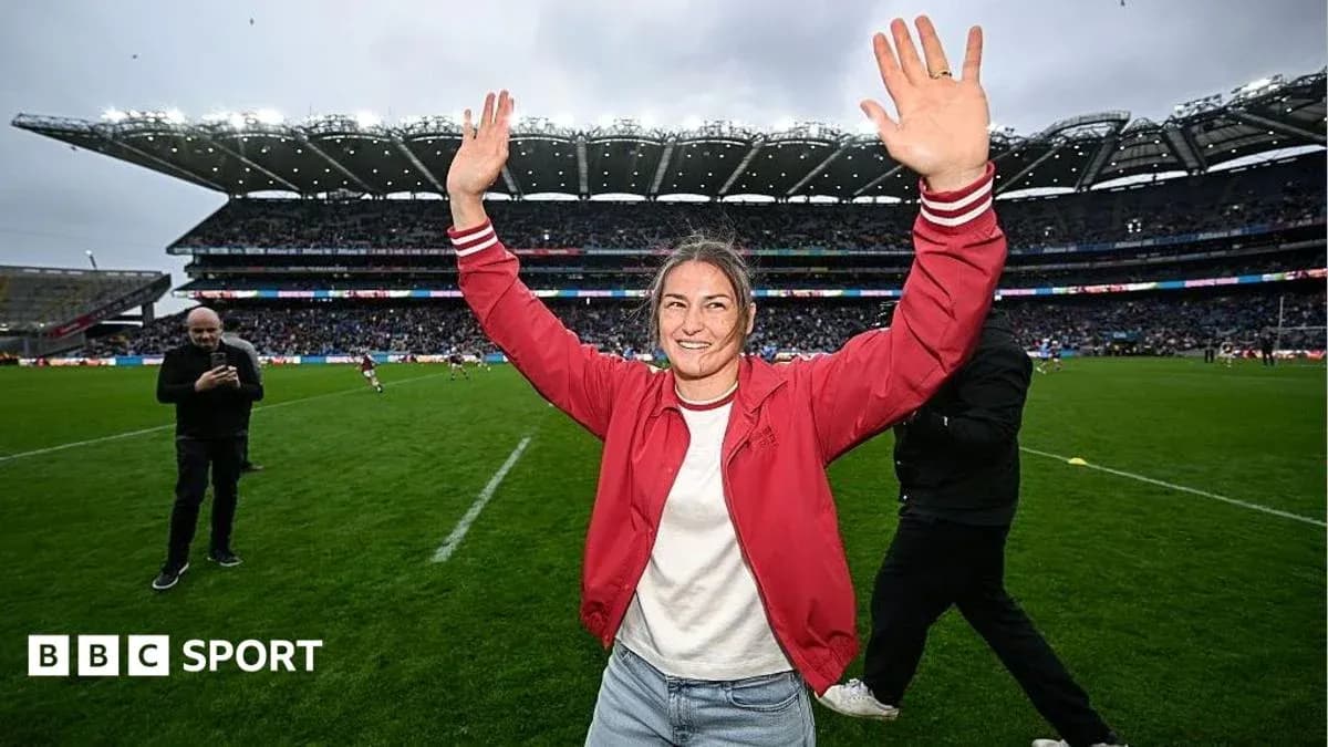 Woman celebrating with raised hands on rugby field