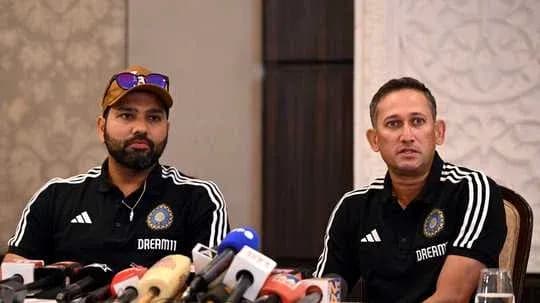 Two coaches at a press conference with microphones
