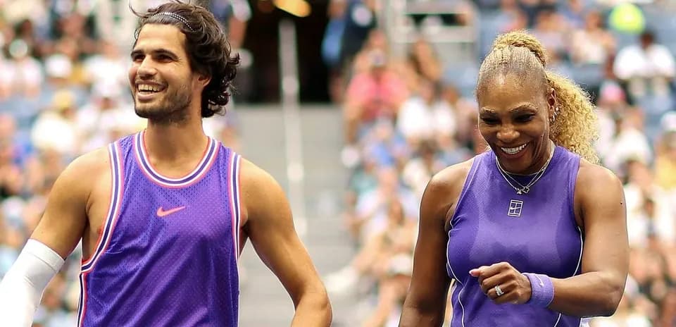 Two tennis players smiling on the court