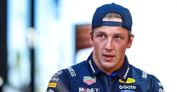 Driver wearing team uniform in paddock area