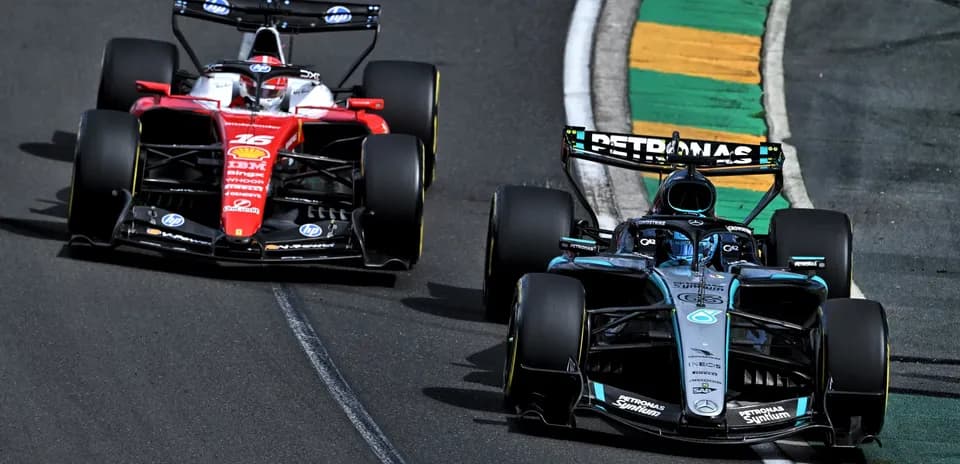 Two Formula 1 cars racing on track corner