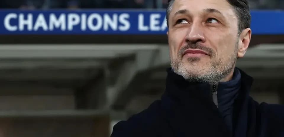 Coach observing match under Champions League banner