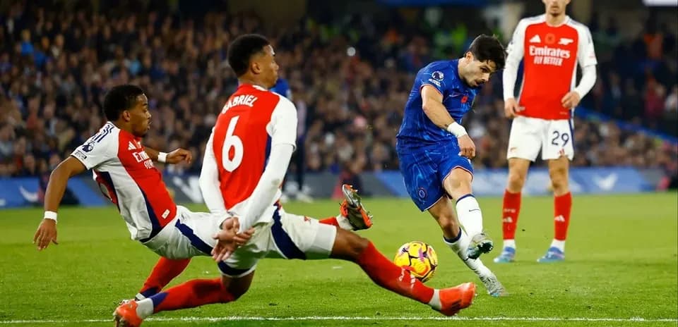 Chelsea player shooting at goal with defenders nearby