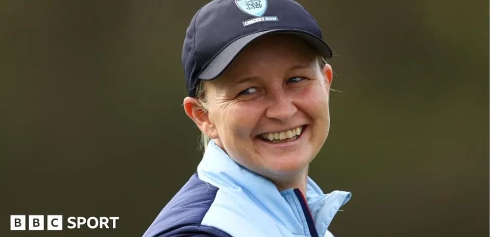 Smiling woman in cricket cap and jacket