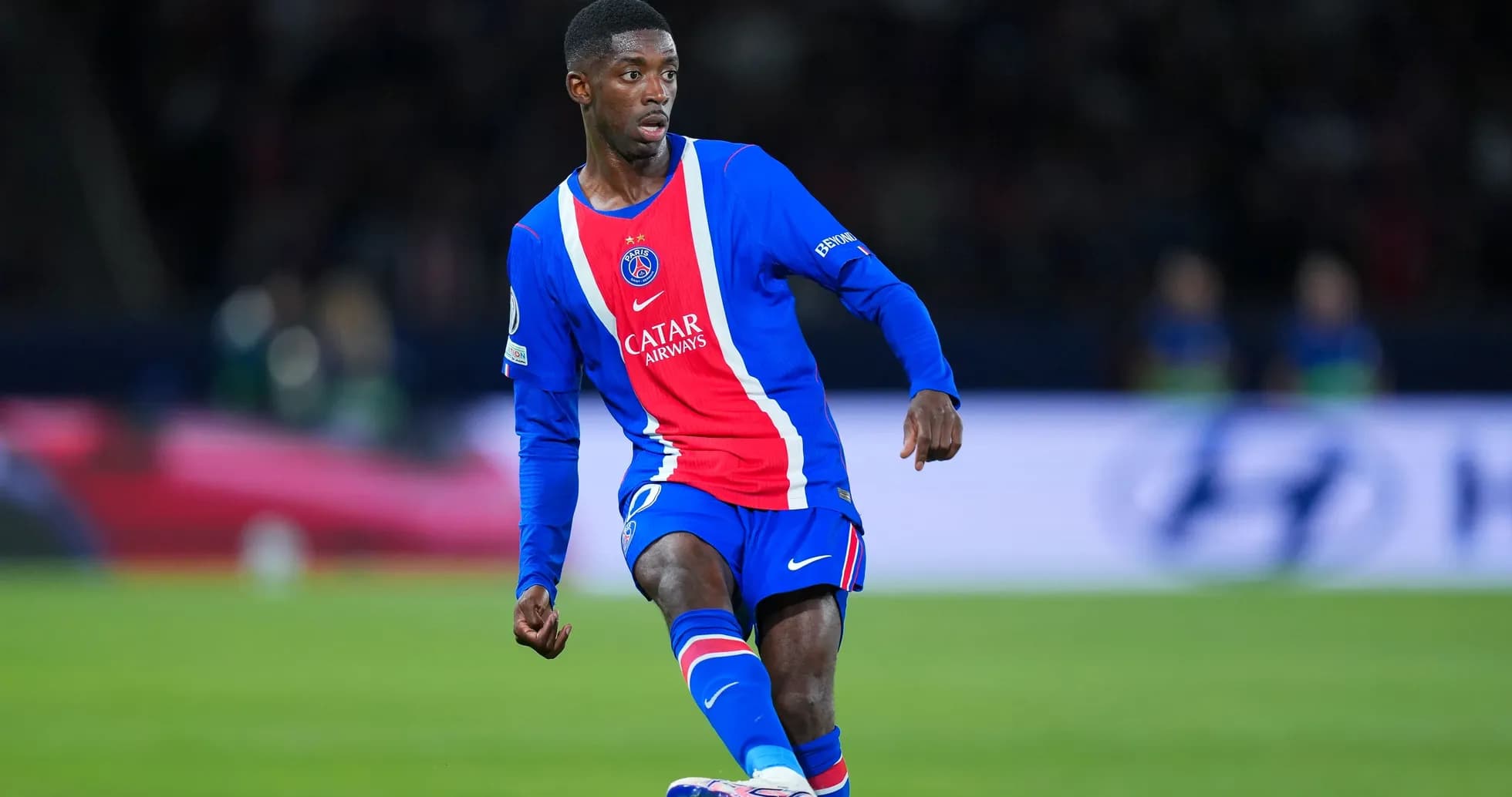 Player in PSG kit dribbling the ball on pitch