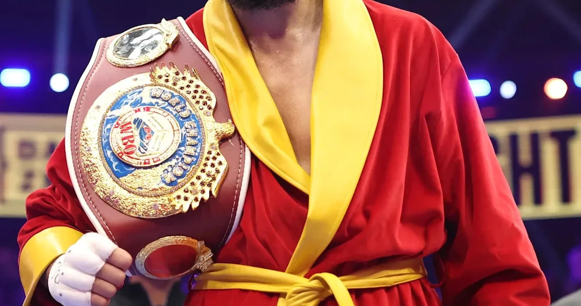 Boxer in red robe holding championship belt