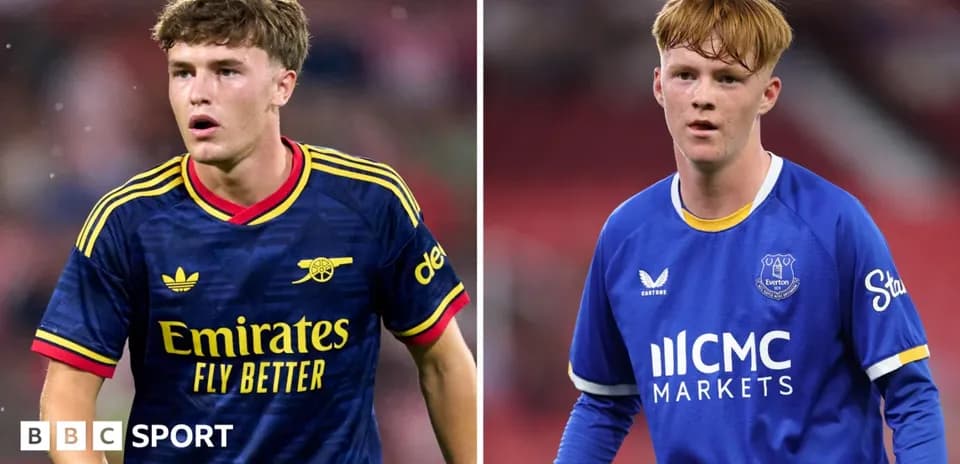 Two football players in team kits on pitch