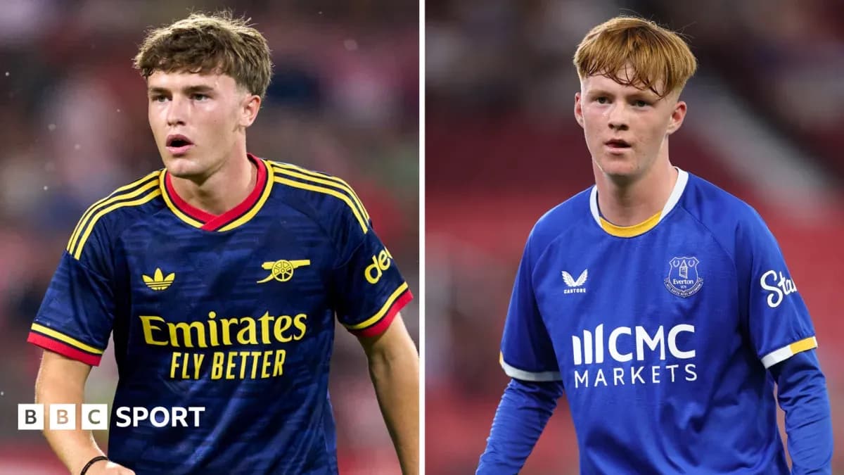 Two football players in team kits on pitch