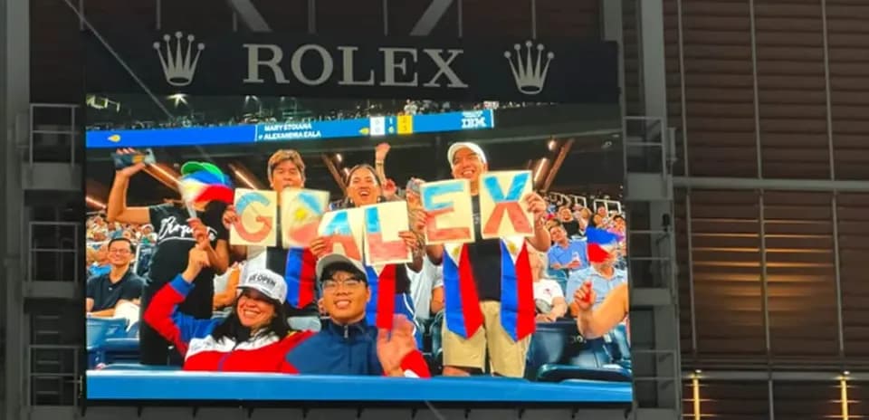 Fans cheering with signs at sporting event