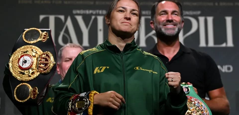 Boxer holding multiple championship belts at event