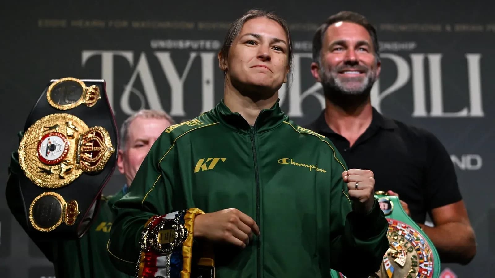 Boxer holding multiple championship belts at event
