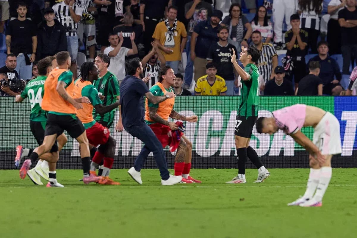 Players celebrating a goal with fans in stadium