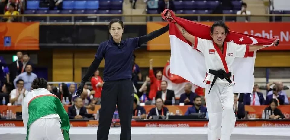 Athlete celebrating victory with national flag in dojo