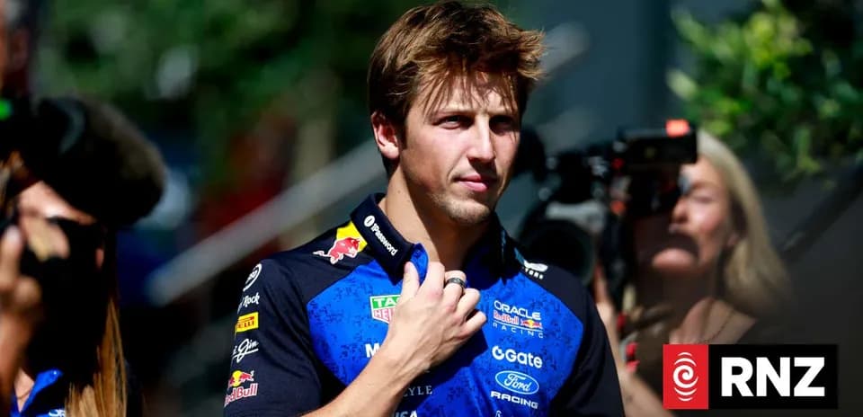Driver in team uniform walking amidst photographers