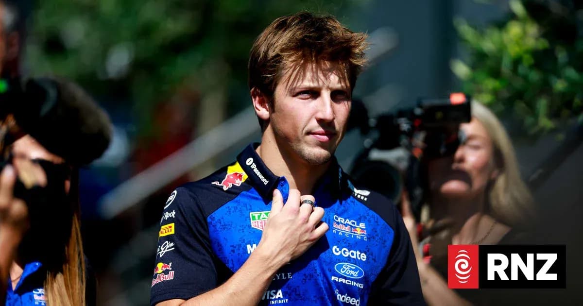 Driver in team uniform walking amidst photographers