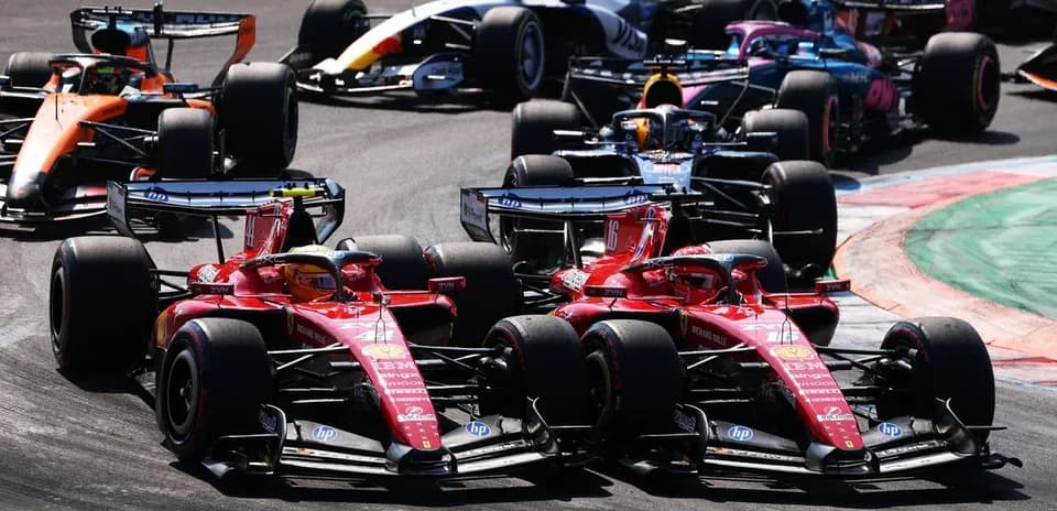 Two Ferrari cars racing closely on track