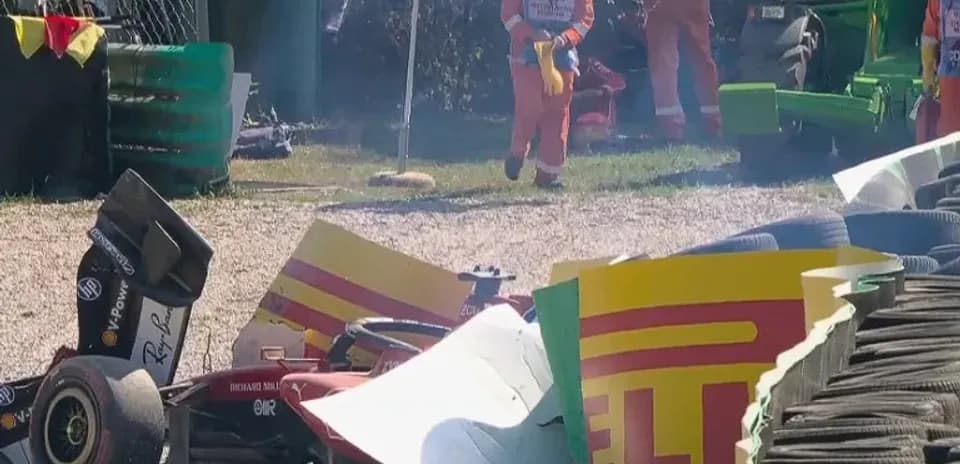 Damaged race car near tire barriers after crash