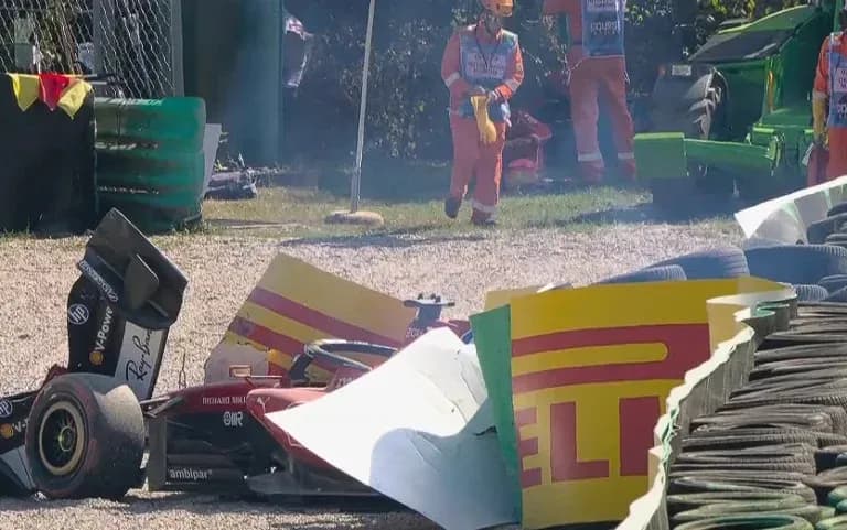 Damaged race car near tire barriers after crash