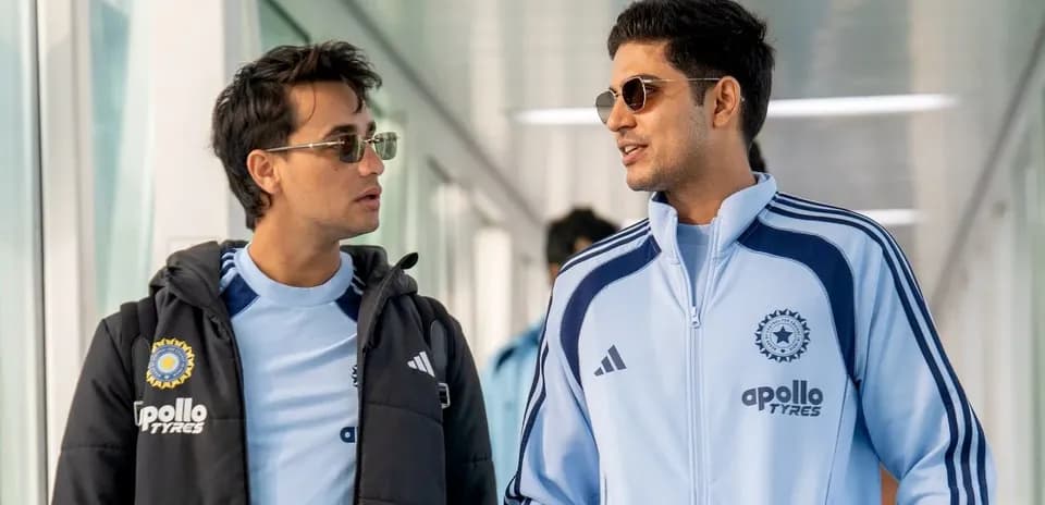 Two players walking in team tracksuits at venue