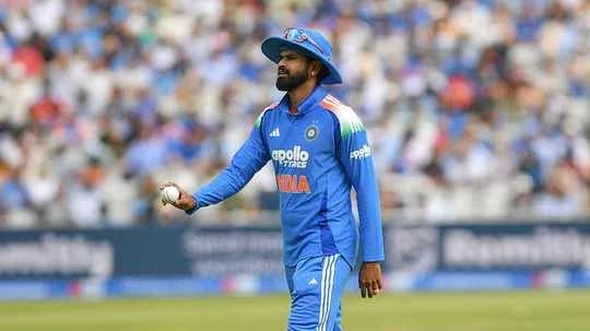 Player in blue uniform holding a cricket ball