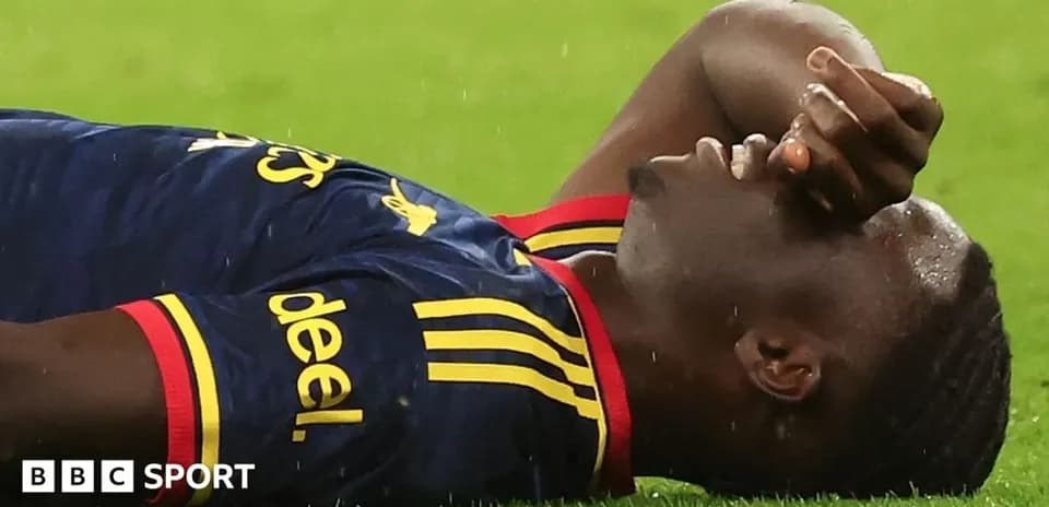 Player lying on ground during match, rain falling