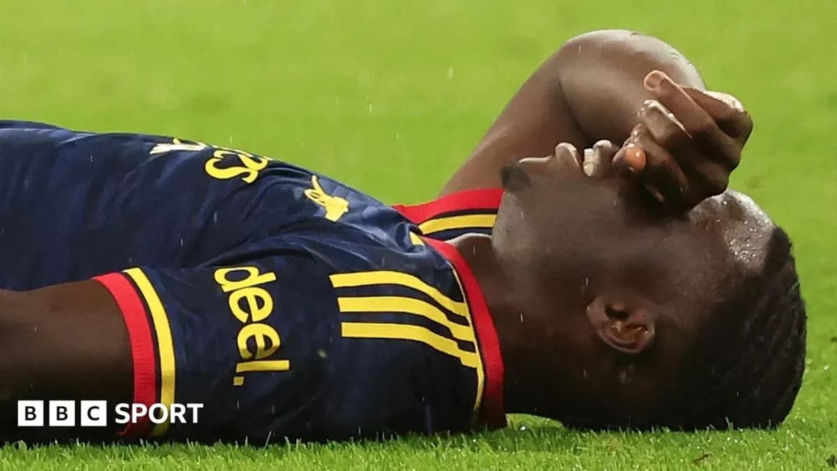 Player lying on ground during match, rain falling
