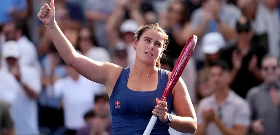 Tennis player celebrating with raised hand and racket