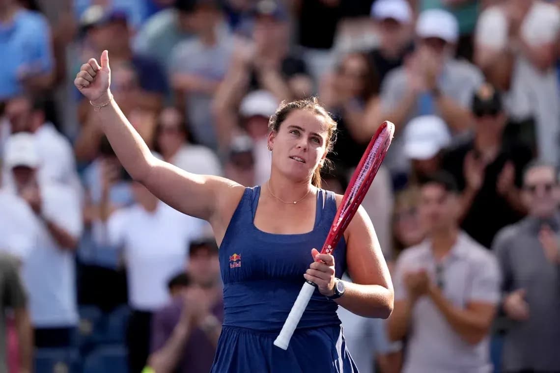 Tennis player celebrating with raised hand and racket