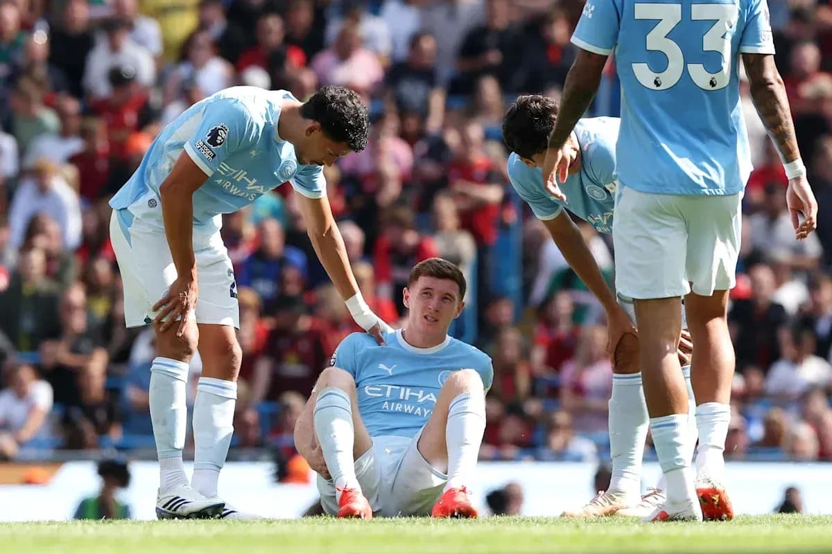 Manchester City players attending to injured teammate