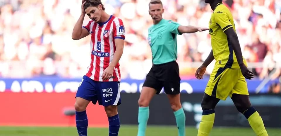 Atletico Madrid player reacts during match with referee