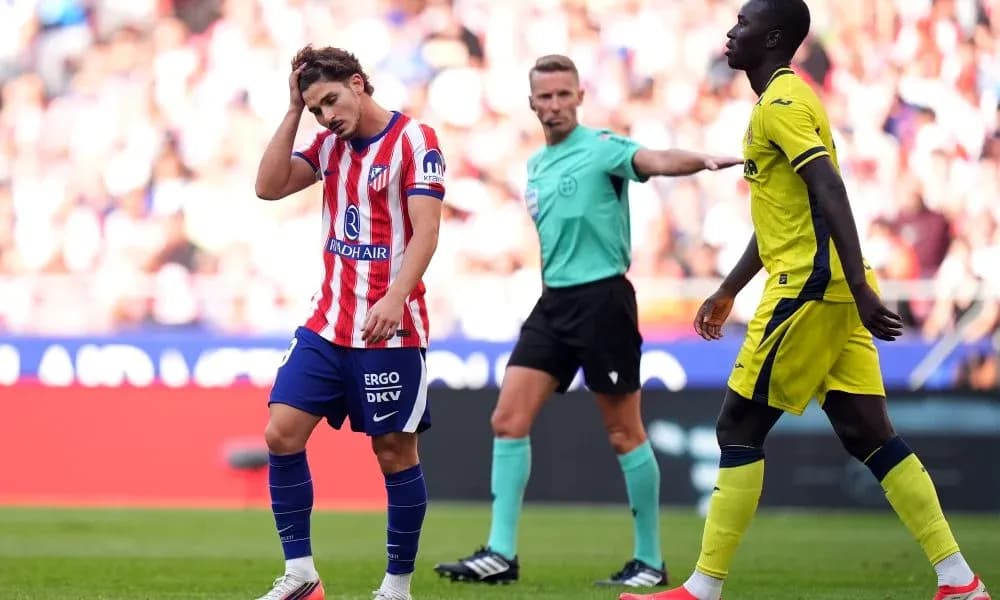 Atletico Madrid player reacts during match with referee
