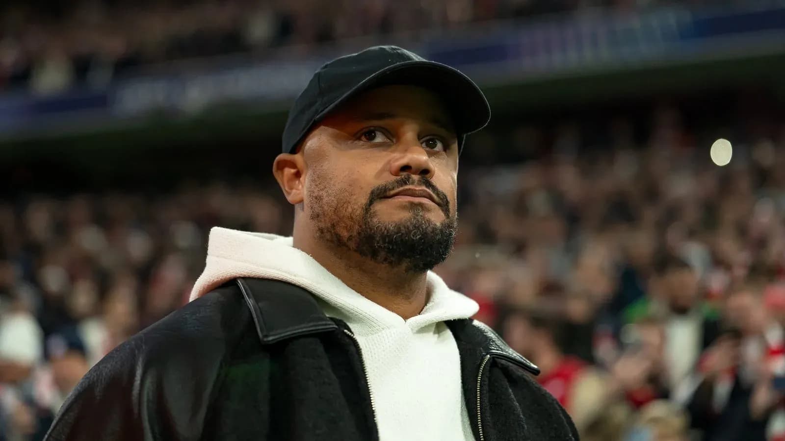 Man wearing a cap and jacket in stadium crowd