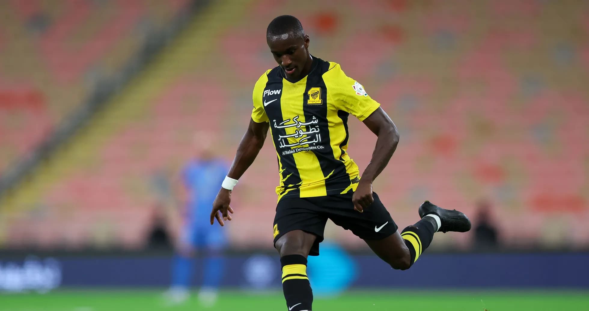 Player in yellow and black kit kicking a soccer ball