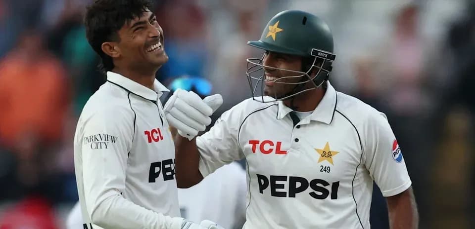 Two Pakistan cricket players celebrating together on field