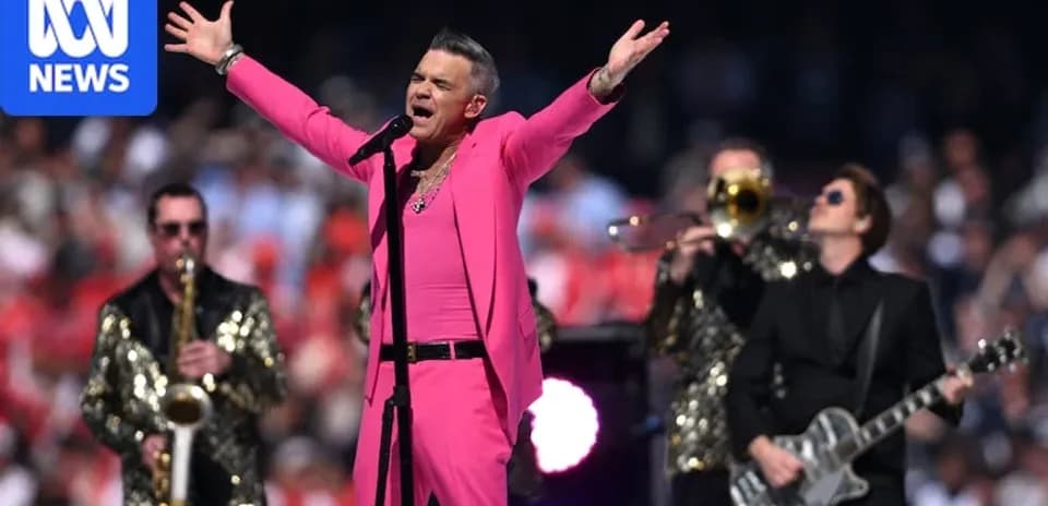 Performer in pink outfit singing with band