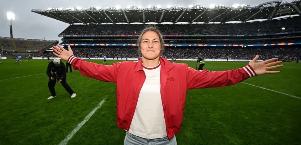 Woman with arms outstretched on sports field