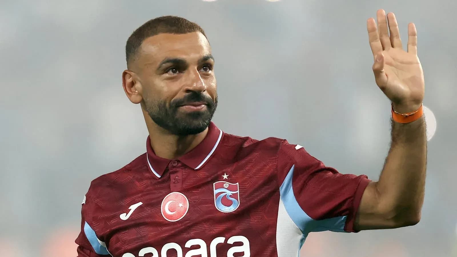 Player waving while wearing Trabzonspor jersey