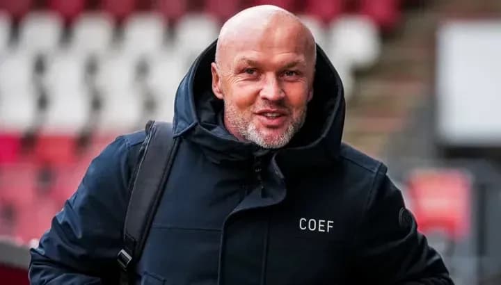Man in dark jacket entering stadium area