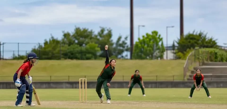 Bowler delivering a ball in cricket match