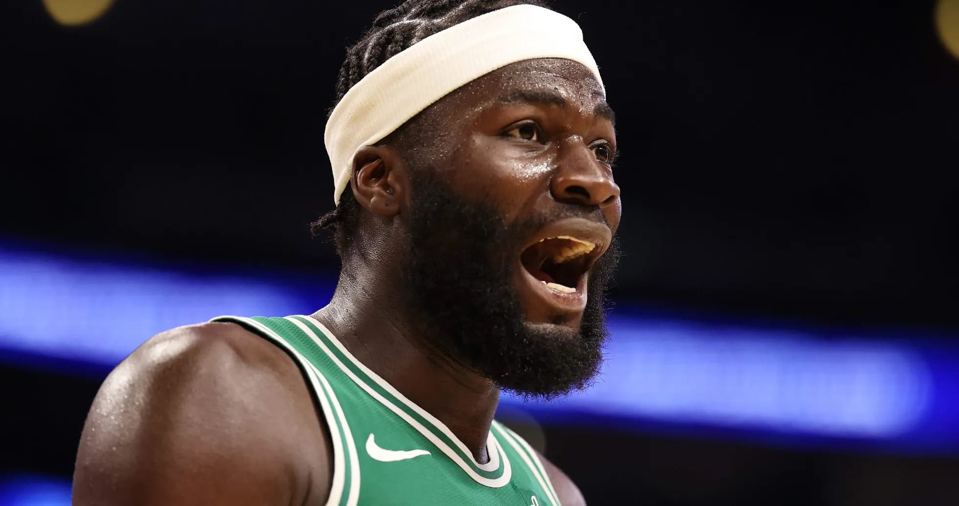 Player shouting on court wearing green jersey