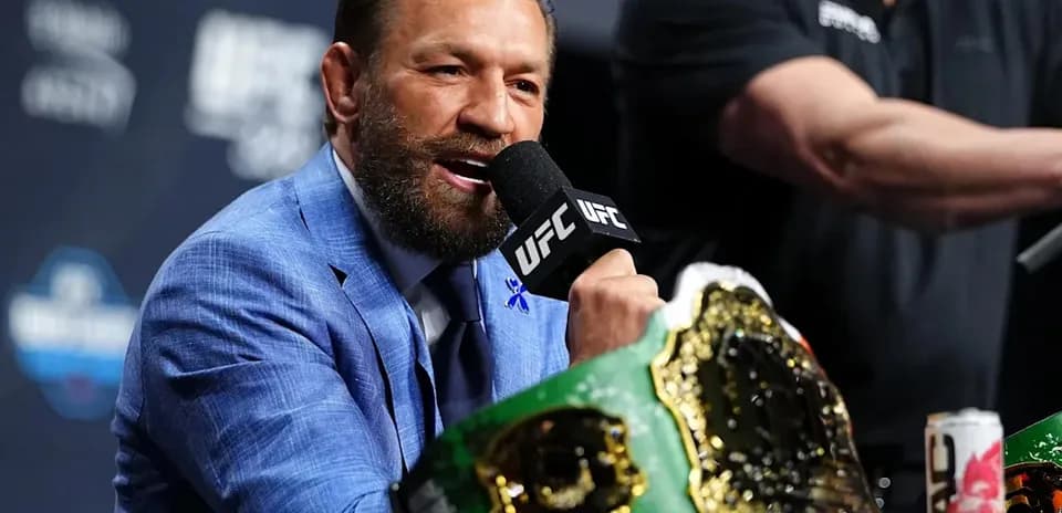 Fighter speaking at press conference with championship belt