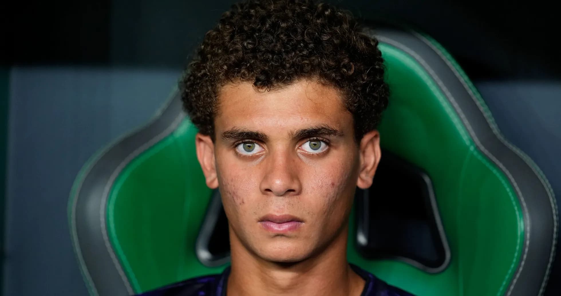 Young player seated in sports chair, focused expression