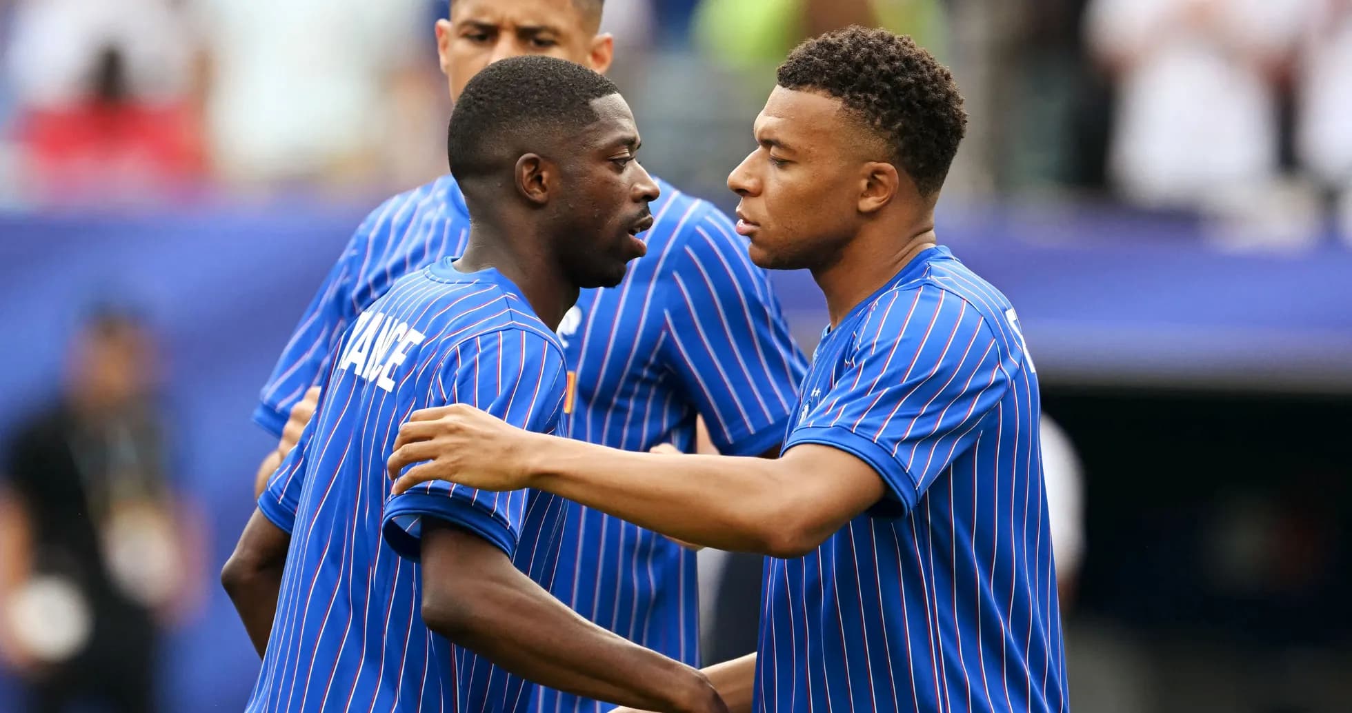 Two players in blue jerseys greeting each other