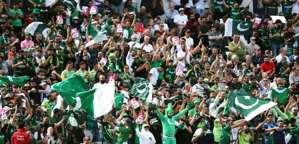 Crowd of Pakistan fans cheering with flags