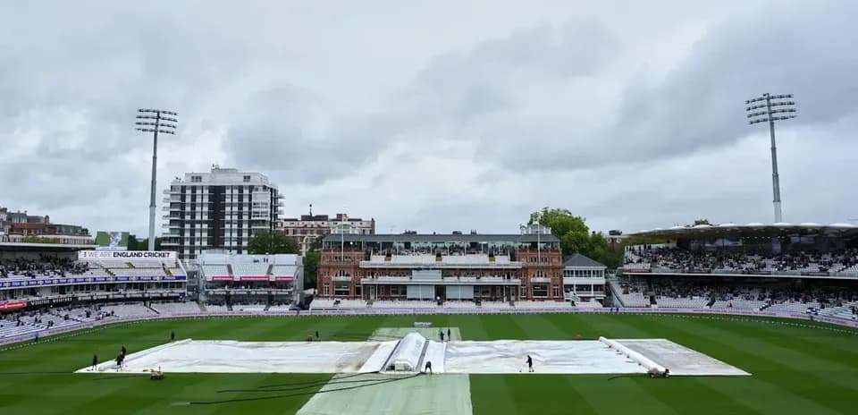Ground staff covering pitch with tarpaulin at Lord's