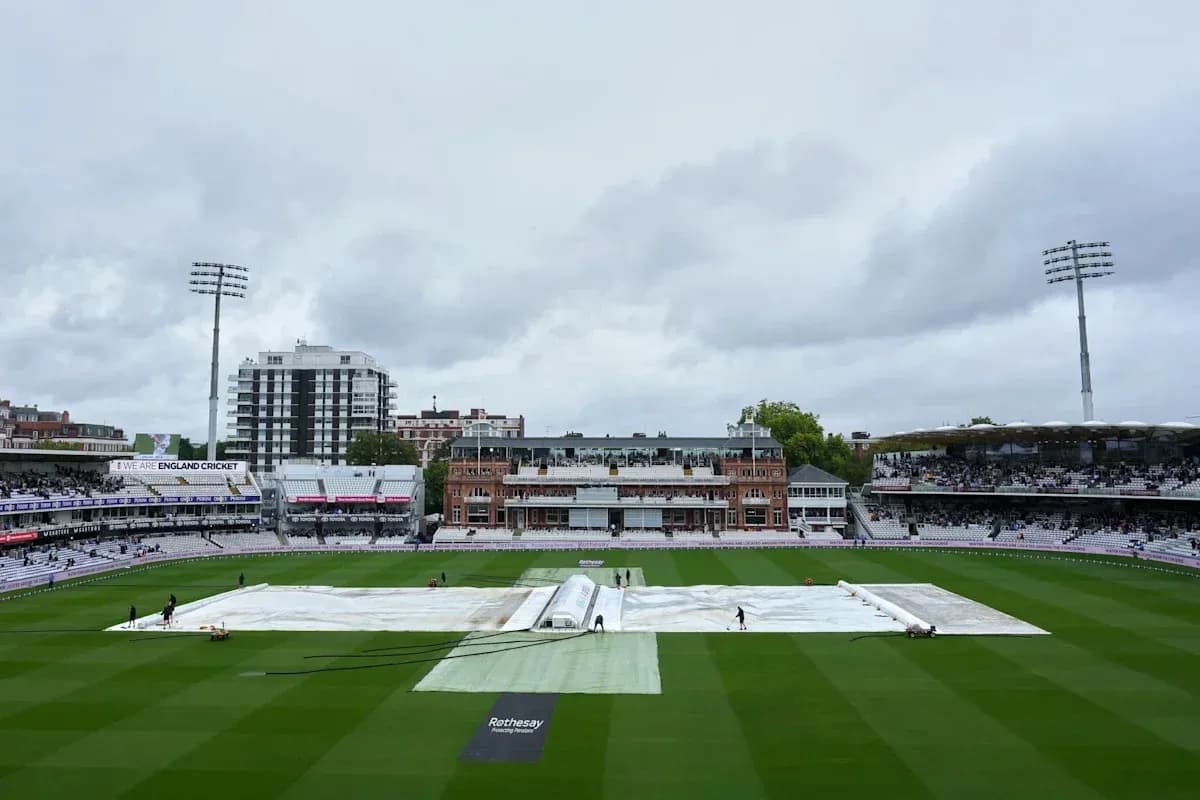 Ground staff covering pitch with tarpaulin at Lord's